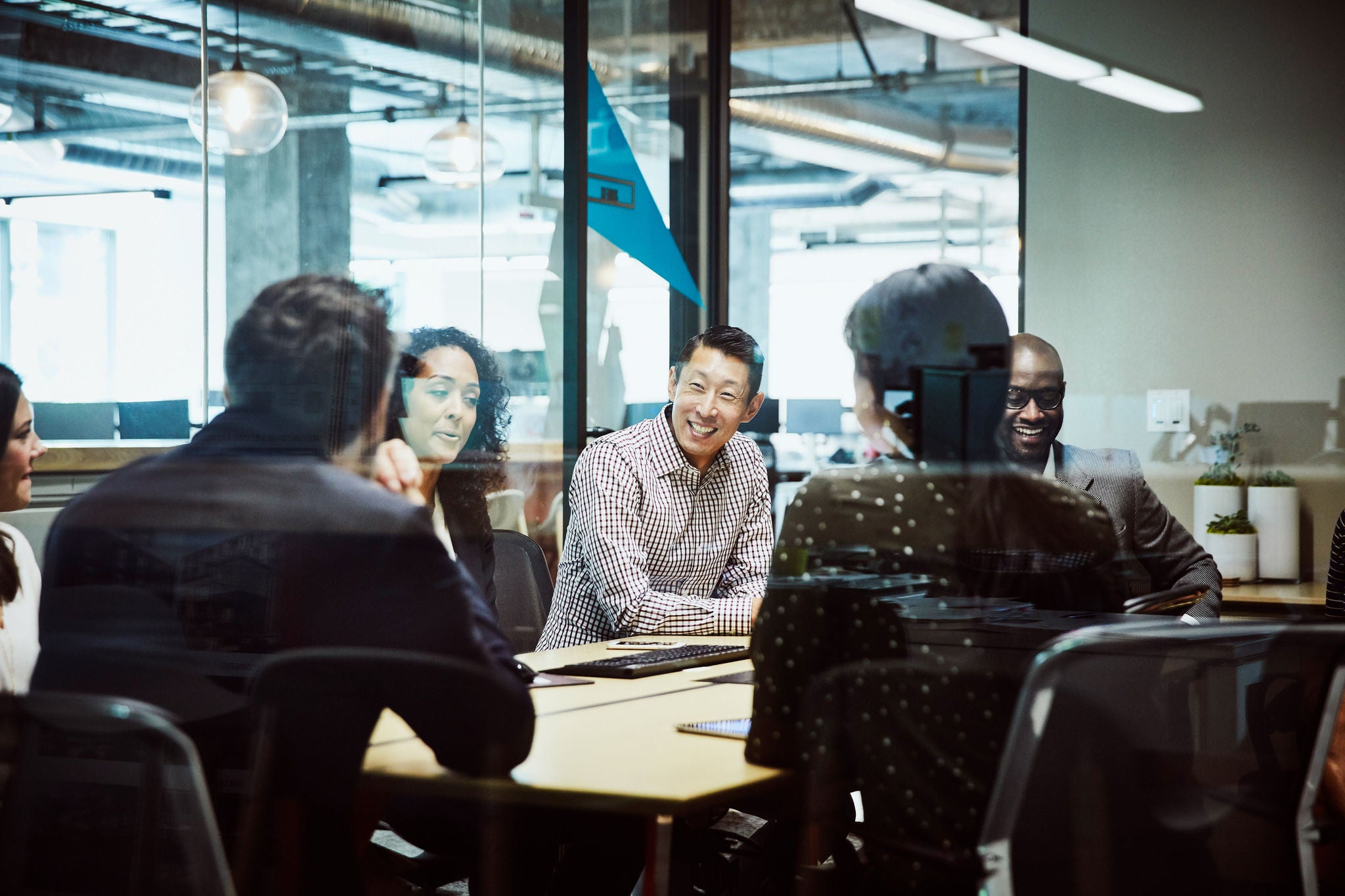 Smiling businessman leading client meeting in office conference room